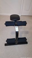 Front view of the sit up bench showing padded foot rollers and cushioned back support.