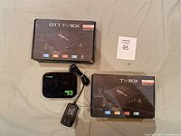 Photo showing two OTT TV Box A95X Pro packaging boxes and one OTT TV Box device with power adapter.