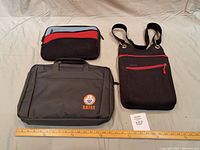 Three mini laptop carry bags displayed with measuring rulers to show size: black SAISE logo laptop bag, red and gray small soft case, and black crossbody bag with red zipper pocket.