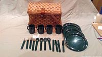 Front view showing picnic basket, plates, cups, and utensils laid out