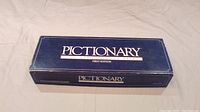 Blue rectangular box with 'Pictionary First Edition' text on top.