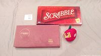 Classic Scrabble game box and a red fabric apple-shaped container for Apple Letters letter tiles along with an Apple Letters box.