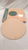 Photo showing the top cooking surface of the pizza stone with original box in background