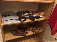 Shelf with men's shoes, belts, and folded dress shirts