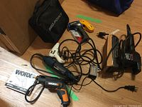 Black & Decker and WORX detail power tools with cords and manuals visible on floor