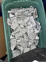 Bin of individually wrapped N95 face masks in green bin, unopened in sealed packaging