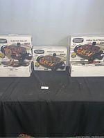 Five boxed Granitestone Diamond 12-inch electric skillets arranged on a table, showing front and side packaging views.