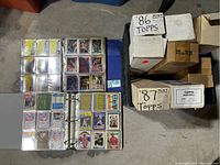 Binder opened showing baseball and basketball cards organized in plastic sleeves