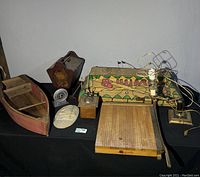 Photo showing the entire lot including billiards lamp, wooden boat book holder, paper cutter, clock, coffee grinder and decorative panel