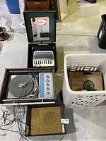 Overview of the lot showing the accordion, record player, speaker, and basket of records