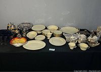 Overview of complete Lenox china set including cups, plates, bowls, and silver pieces.
