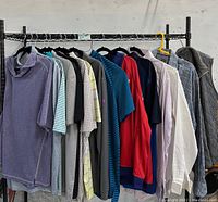 Rack showing multiple men's shirts and vest, size XL, various colors and styles hung closely on hangers.