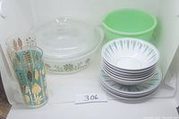 Full lot of mid-century kitchen items: Mikasa blue point bowls and saucers stacked, Glasbake casserole with lid, jadeite mixing bowl, and two decorated glasses. Shows overall lot condition and items need cleaning.