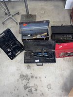 Overview of all toolboxes, cases, and tools grouped on floor showing assortment in lot.