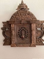 Front view of carved wooden peacock window wall sculpture