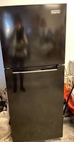 Front view of Magic Chef black refrigerator with closed doors.