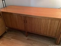 Full angled view of the teak cabinet showing overall form and legs