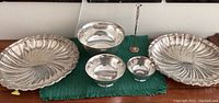 Two large Gorham platters, two footed bowls and a slender bud vase on green mat