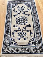 Full view of blue and white rug laid on hardwood floor showing overall pattern and proportions