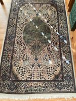 Full view of rug laid flat on floor showing overall pattern, colors, and fringe
