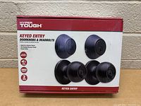Front view of packaged Hyper Tough keyed entry door knobs and deadbolts showing product name, features and images of hardware.