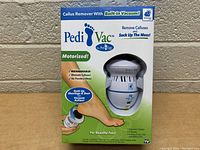 Front side of Pedi Vac callus remover box showing device through window, highlighting motorized and rechargeable features with built-in vacuum suction for callus removal.