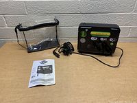 Full front view of the Slime portable flat tire air pump with attached hoses, user manual and clear carrying case.