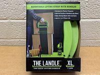 Front view of The Landle XL lifting strap packaging showing strap and handles through clear plastic, with text detail on box about use and weight capacity.