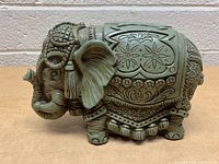 Front view of the vintage elephant coin bank showing detailed designs on the body and head.