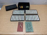 Overall set displayed showing Mahjong tiles arranged on trays with instruction booklets and open box.