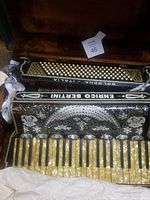 Image of the full accordion showing ornate decorative grill with brand name Enrico Bertini and keyboard keys with pearlescent finish.