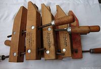 Four wooden Jorgensen 10 inch woodworking clamps showing wooden bodies with metal screws and wooden handles.