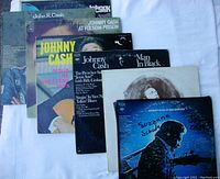 Photo showing 7 Johnny Cash vinyl albums with visible front covers including At Folsom Prison, Man In Black, and Greatest Hits.