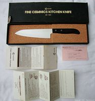 Kyocera fine ceramics kitchen knife in original box with cork lining and all paper documentation (manual and warranty) displayed.