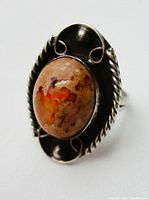 Close-up view of oval stone showing iridescence and color variations.