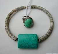 Ring and bracelet displayed together showing the ring with an oval turquoise stone and the bracelet with heishi beads and a large turquoise stone centerpiece.