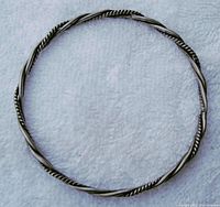 Full view of a twisted pair silver bracelet with alternating rope-like texture and smooth wire twisted around each other.