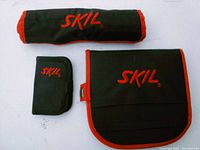Three black canvas pouches with red trim labeled with Skil logo, rolled and folded.