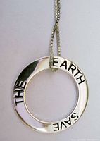 Front of circular pendant on necklace showing inscription 'SAVE THE EARTH' with attached sterling silver box chain.