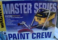 Front of sealed box showing Wagner Master Series PistonPainter Paint Crew unit, spray gun and coiled hoses