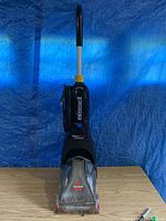 Full front view of Bissell ReadyClean PowerBrush carpet cleaner showing handle, body, clear front nozzle area, and brand name.