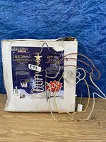 Box and partially assembled spiral Christmas tree with star topper and support base