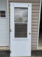 White exterior door with glass window and screen panel, hinges, and a hole for door handle.