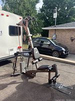 Left front three-quarter view of gym showing frame, seat, pulleys and weight stack