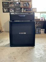 Amp head positioned on top of speaker cabinet in workshop setting