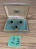 Costume jewelry set with green stones in original Mappins box on wood surface, includes necklace and two earrings