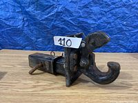 Side perspective of the pinion hitch, showing the curved hook and square attachment shaft with rusted pin.