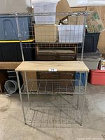 Full front view of metal wire shelving unit with wooden shelf and multiple tiers.