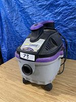 Front angle view of ProGuard shop vacuum showing purple handle, vents, and white base with vacuum hose inlet.