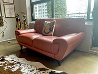 Left-front angle showing tan leather sofa near window